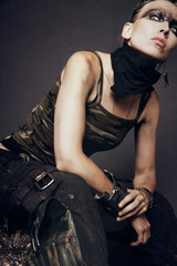 Young woman in brutal futuristic clothes on black background