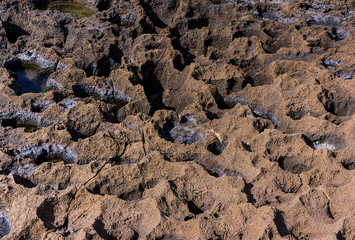 Volcanic background texture rocky coast winded with craters with sea water and the edge of salt