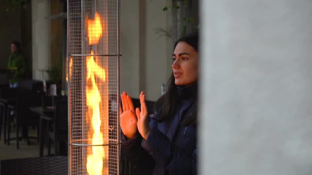 Girl warms near the flame gas infrared heaters
