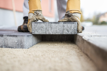 Builder laying outdoor paving slabs - 177585058