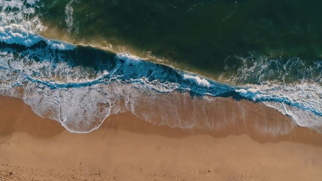 Aerial drone slow motion footage of ocean waves reaching shore