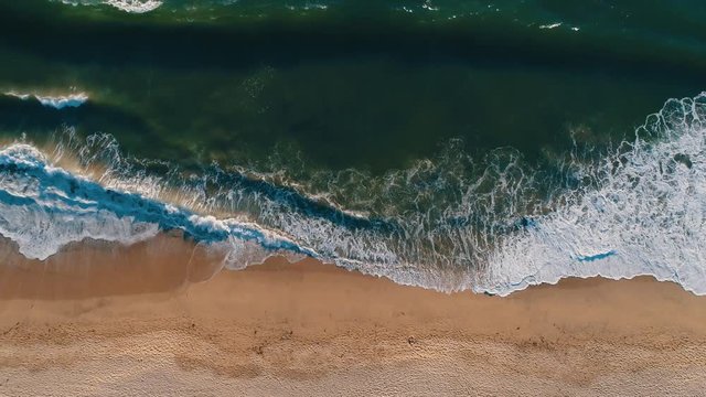 Aerial drone slow motion footage of ocean waves reaching shore