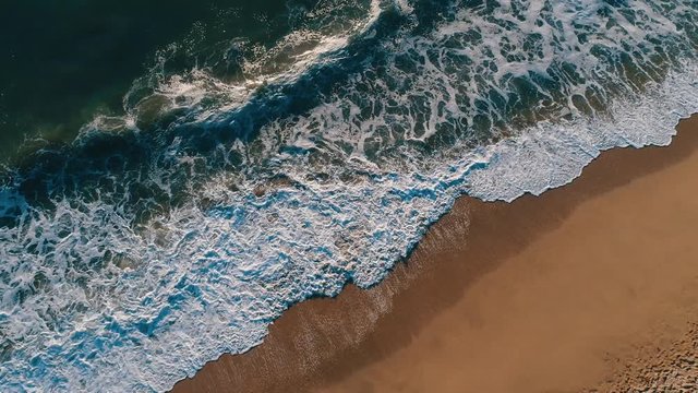 Aerial drone slow motion footage of ocean waves reaching shore