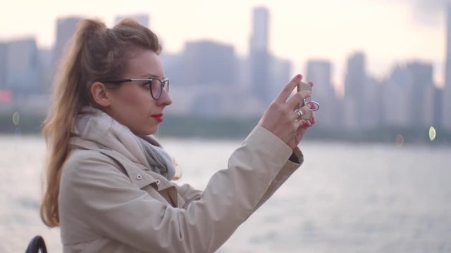 Tourist taking photograph of sunset in Chicago