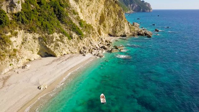 Aerial view of a boat in front of the Corfu island in Greece. Amazing beach with a turquoise and transparent sea
