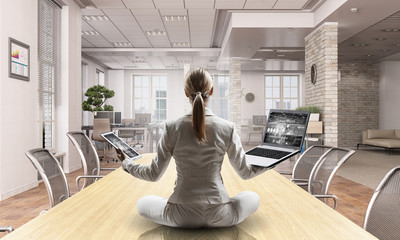 Business lady meditating at work. Mixed media