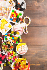 Different unhealthy candies on brown wooden background