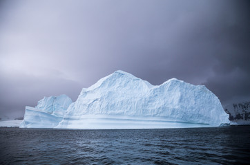 An iceberg that has started to melt, dark background
