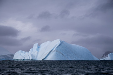 An iceberg that has started to melt, dark background