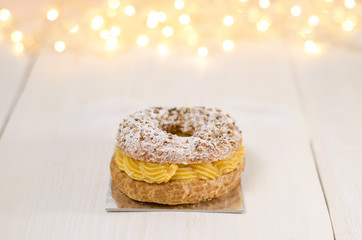 Beautiful cream puff with hazelnuts, delicious desert, Christmas concept, bokeh background , copy space