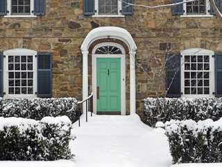 front door of stone house in winter