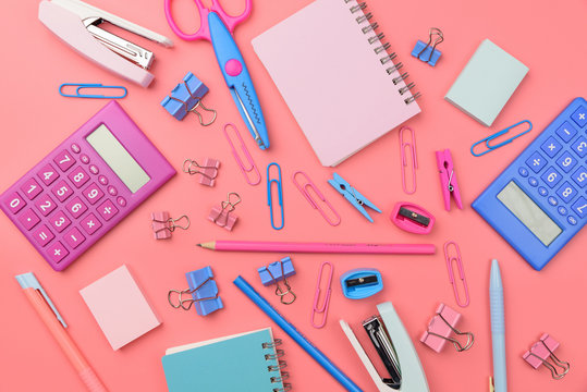 Stationary concept, Flat Lay top view Photo of school supplies scissors, pencils, paper clips,calculator,sticky note,stapler and notepad in pastel tone on pink background with copy space, flat lay 