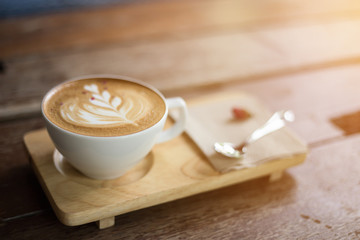 cup of coffee and spoon on wood plate