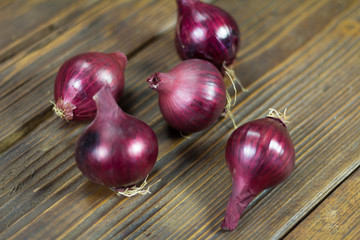 Red organic onion bulb on wooden background