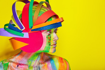Model with colorful abstract makeup in multicolored helmet