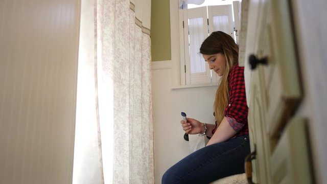 Troubled young teenager discovers that she is pregnant via pregnancy test