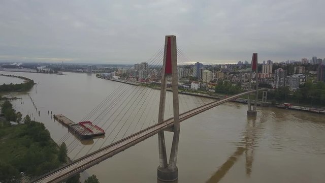 Aerial 4k footage of Pattullo and Skytrain Bridge running across Fraser River from city of Surrey to New Westminster in Greater Vancouver, BC, Canada.