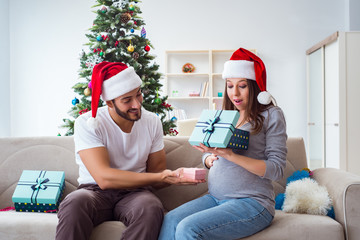 Obraz premium Young family expecting child baby celebrating christmas