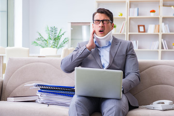 Man in neck brace cervical collar working from home teleworking