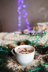 A cup of coffee with Christmas decorations, fir branches, pine cones and garland