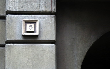 A plate with the number on the wall of an ancient building.