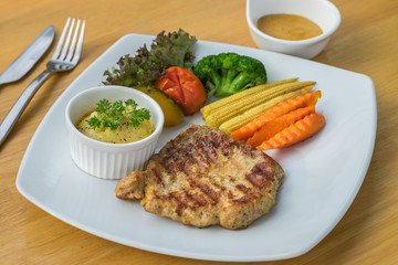 Barbecue pork steak on plate served with mashed potato and vegetables