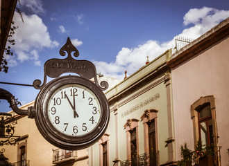 Fototapeta na wymiar SANTIAGO, QUERETARO / MEXICO - 06 22 2017: Traditional clock in Andador 5 de Mayo in Queretaro Mexico