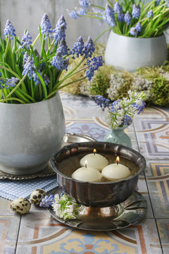Bouquet of muscari flowers (grape hyacinth) and bowl with water and floating candles