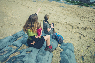 Two women with a baby sitting on the beach