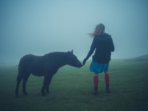Woman petting a wild pony