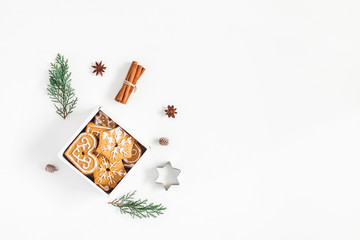 Christmas composition. Christmas gingerbread cookies and pine branches on white background. Flat...