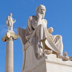 Socrates the philosopher and Apollo the god of arts, music and poetry statues on blue sky background