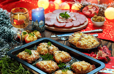 Christmas baked chops with cheese and cold cuts platter, served on the old wooden table