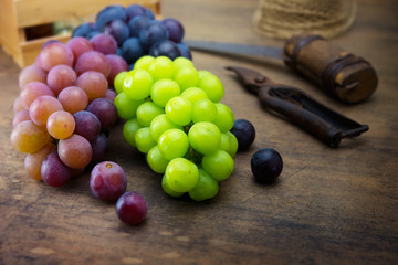 Harvest season. Fresh harvested red, black and white (green) grapes on a table.
