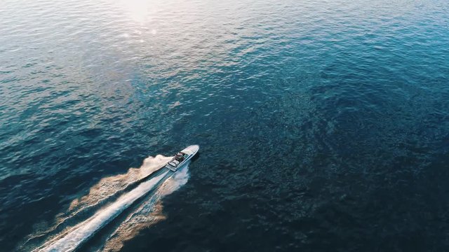 Bird eye view of luxurious speed boat sailing on the turquoise lake. It perfectly describes traveling to new amazing destinations and summer vacation on the lake