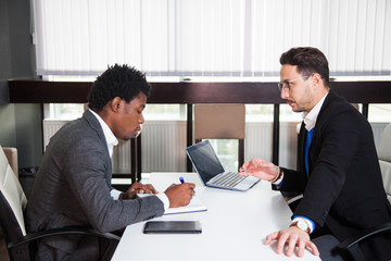 Two young businessmen, white desk, job interview, teamwork