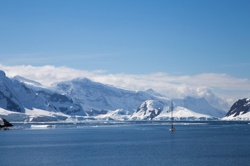 A sailing ship sails through the neumayer channel, Antarctica.