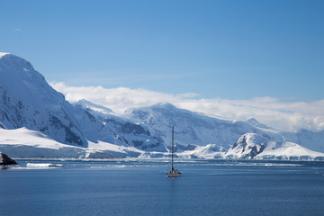 A sailing ship sails through the neumayer channel, Antarctica.