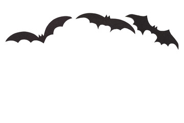 Silhouettes of volatile bats carved out of black paper are isolated on white