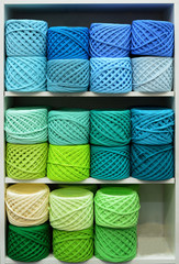 Colorful Balls Of Wool On Shelves. Variety of knitting yarns. Different Yarn balls in multiple colors. Yarn Storage.