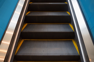 Empty escalator or moving stair. Also called stairway or staircase. Modern architecture design with step, glass for lift people up floor building i.e. shopping mall, airport, metro and subway station.