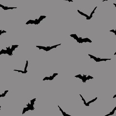 Black silhouette of spooky bats against grey background. Vector illustration, seamless pattern