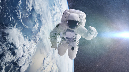 astronaut in orbit of planet Earth lit by the Sun and the Milky Way galaxy  © dottedyeti
