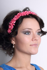 Fototapeta premium Beautiful young brunette woman with wreath on her head and make-up on grey background, look throw