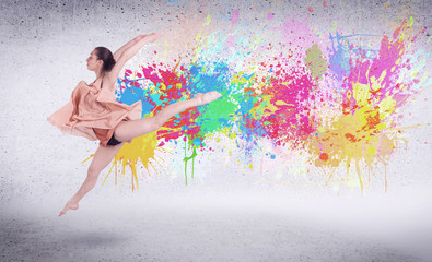 Modern street dancer jumping with colorful paint splashes