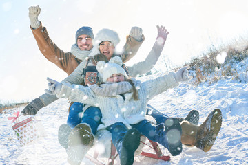 Familie beim Schlitten fahren im Winter - obrazy, fototapety, plakaty