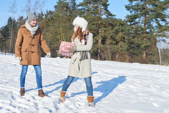 Paar mit einem Geschenk im Winter