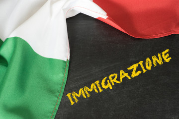 Italienische Flagge, Kreidetafel und das Wort Zuwanderung