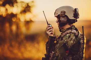 military soldier with weapons at sunset. shot, holding gun, colorful sky. military concept.