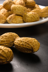 Peanuts in shell on dark background, close up